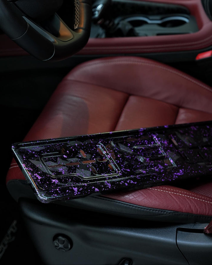 Car interior with a purple and black license plate on a red seat